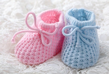 A pink and blue baby shoe, highlighting gender disappointment.