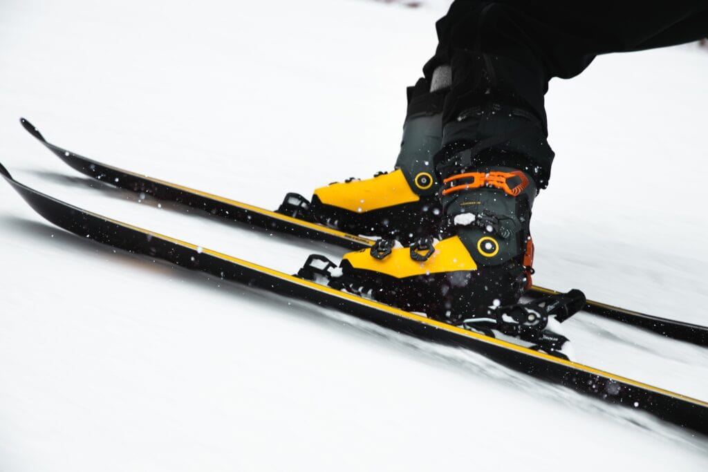 Ski boots and skis on the snow. Photo by Ethan Walsweer on Unsplash