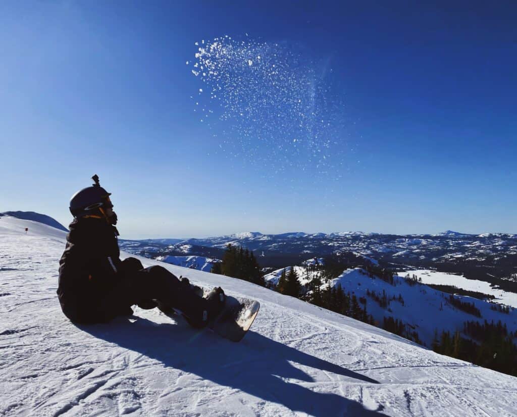 A snowboarder sits on the slope. Photo by Cyrus Crossan on Unsplash