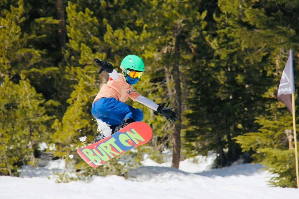 Someone riding a junior snowboard with Burton written underneath. Photo by Alexander Simonsen on Unsplash