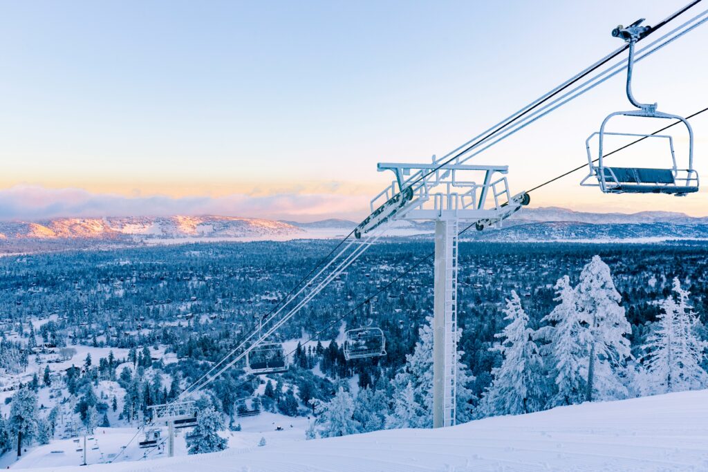 A ski lift with mountains in the background. Photo by Big Bear Cabins on Unsplash