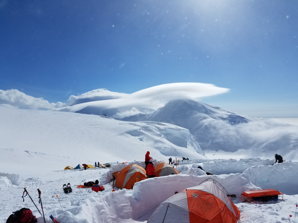 Several tents in the snow with snow walls protecting them from the wind. Photo by Paul Van Lake on Unsplash