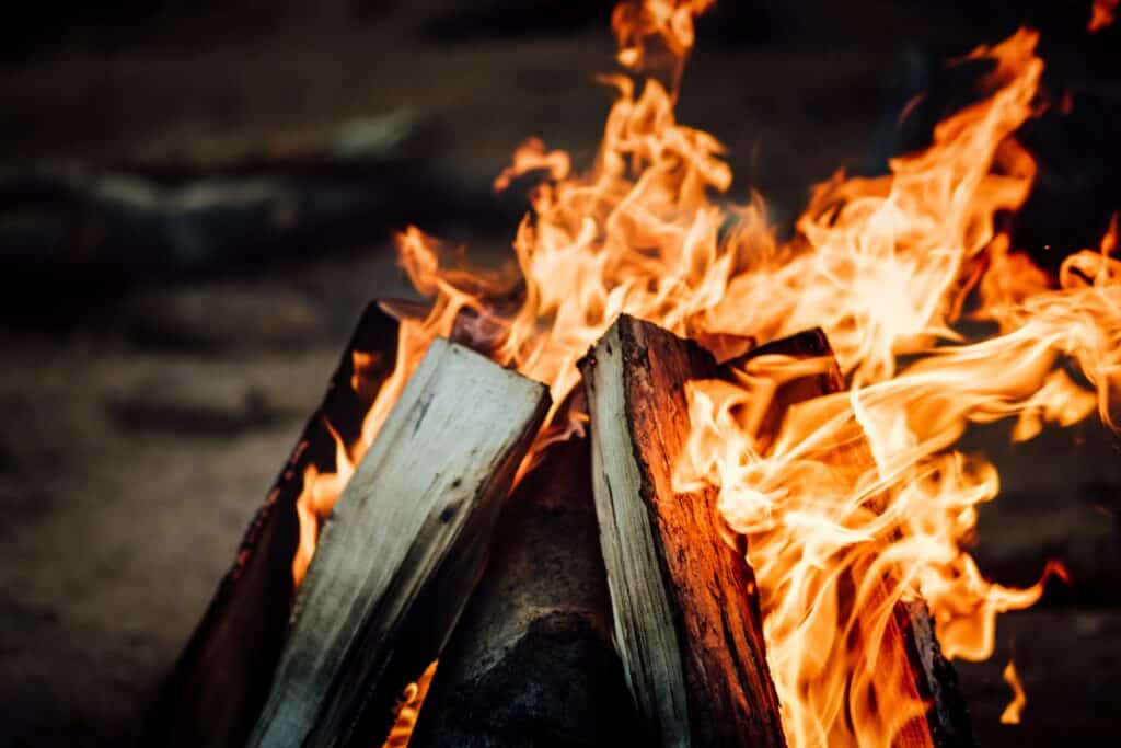 A campfire with wood stacked against each other. Photo by Tim Foster on Unsplash