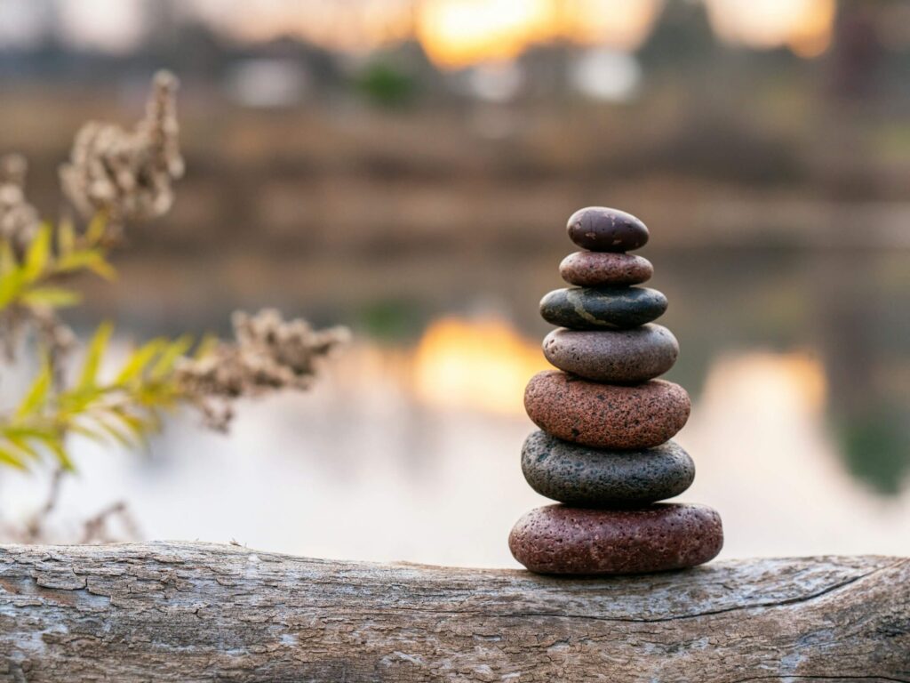 Stones balancing on top of each other outside. Photo by Brad Switzer on Unsplash