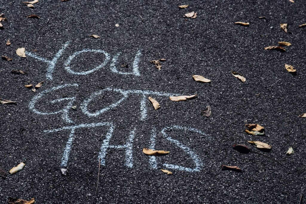 A You Got This sign written in chalk on the ground. Solo camping. Photo by sydney Rae on Unsplash