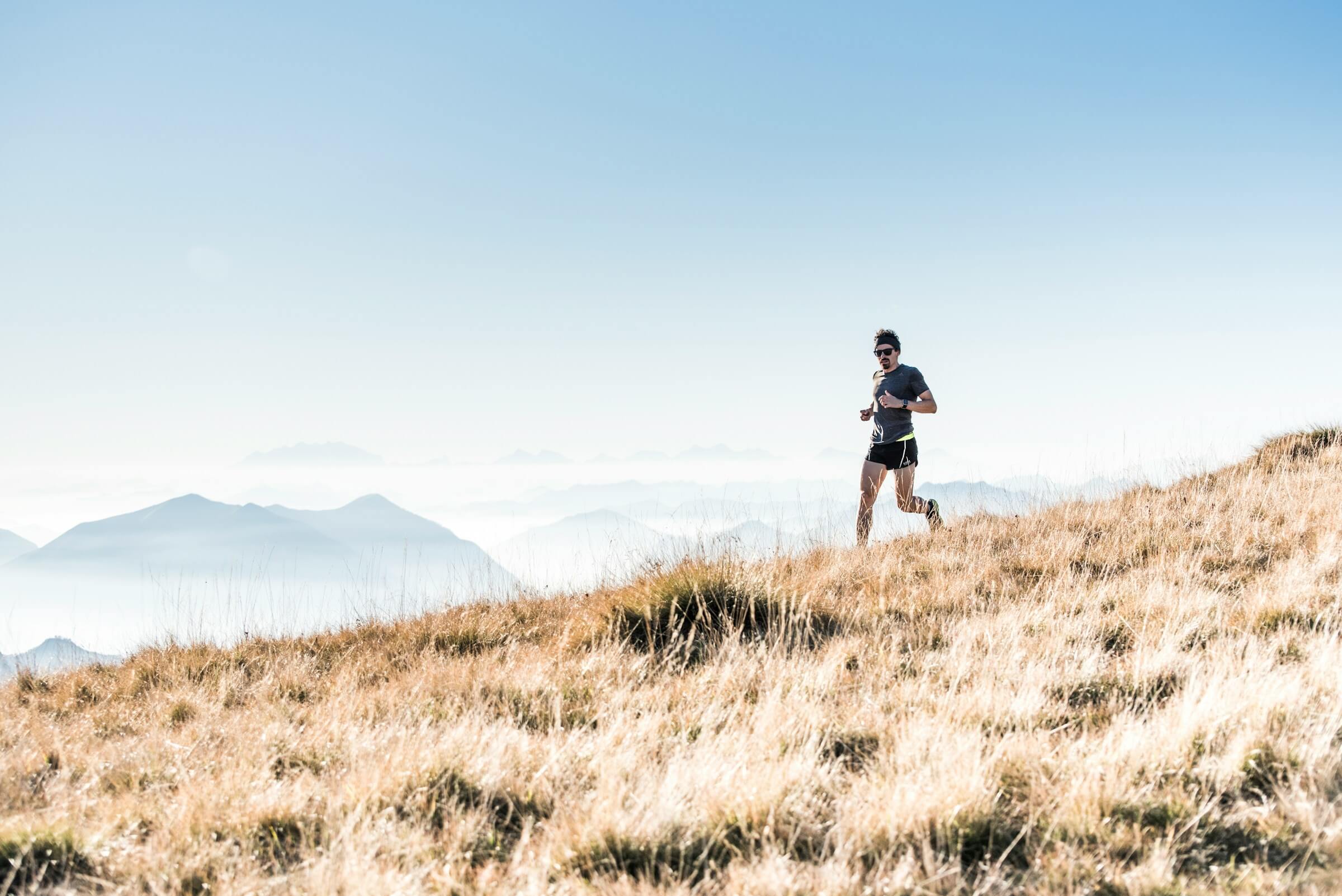 What is trail running? A runner running up in the mountains. Photo by Alessio Soggetti on Unsplash