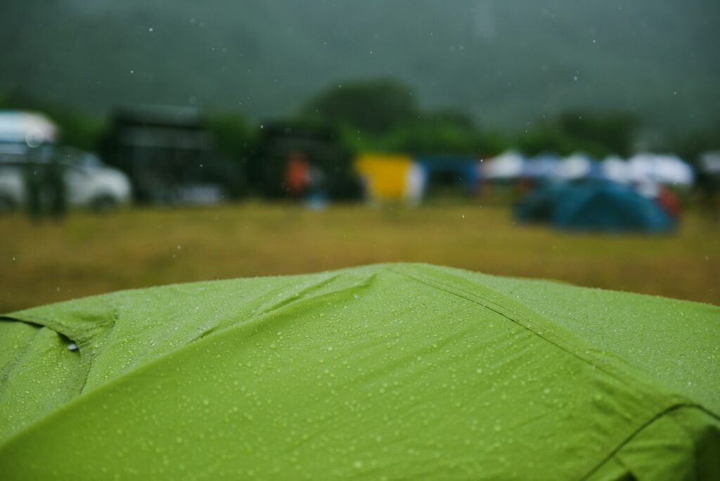 Rain droplets on a green tent. Photo by Suhyeon Choi on Unsplash