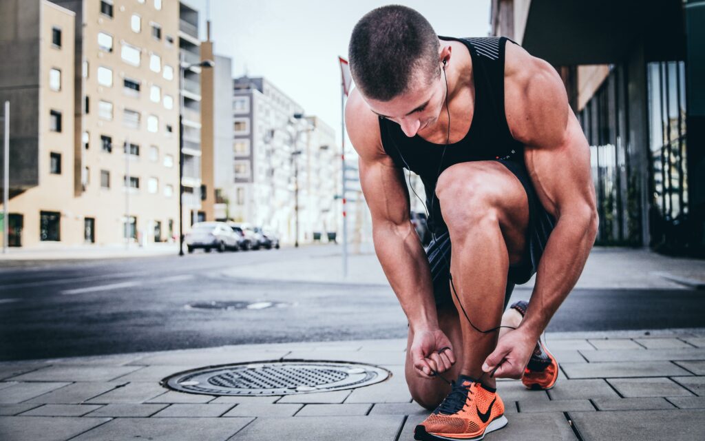 A man tying up his running laces. Photo by Alexander Redl on Unsplash