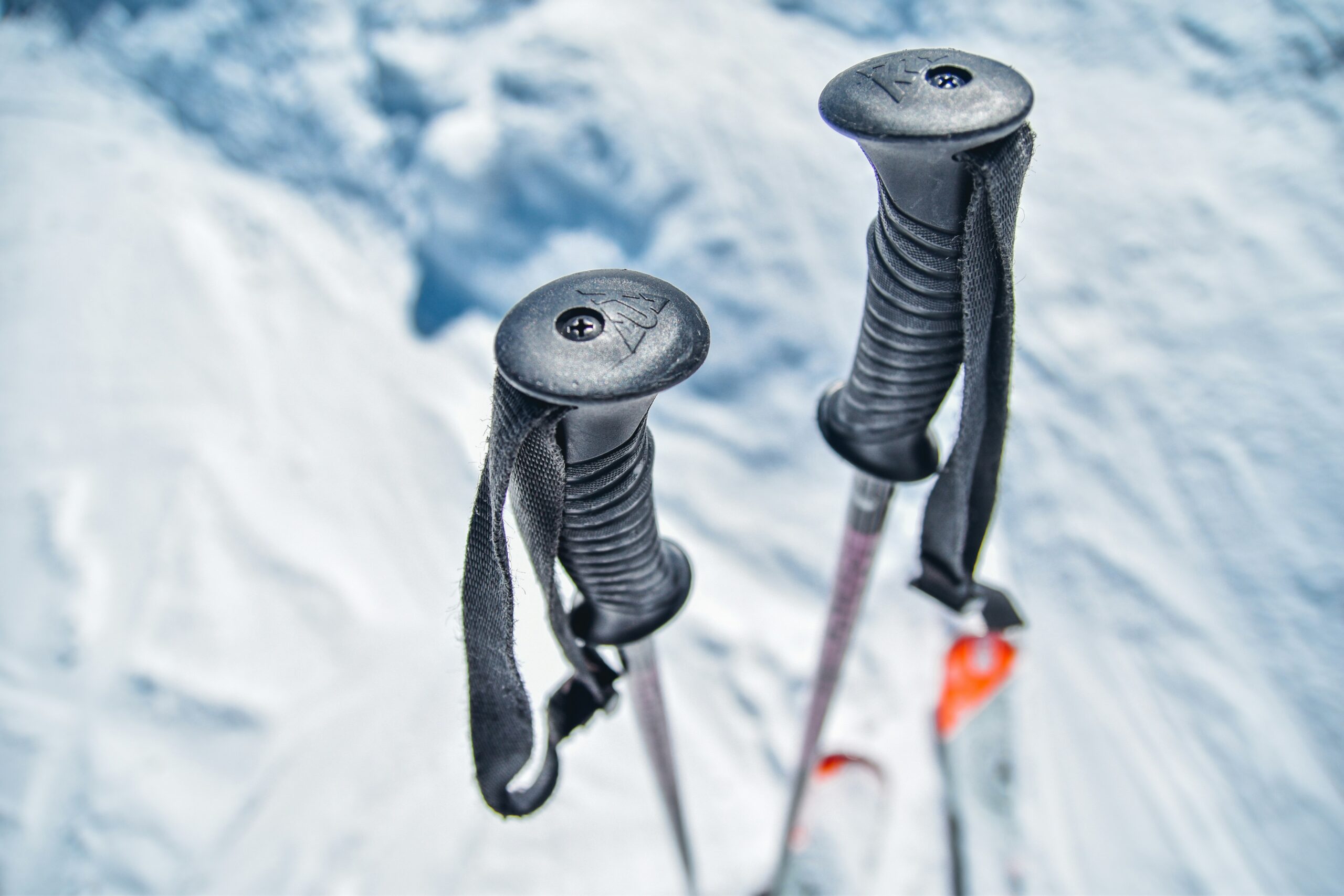 A close-up of ski poles in the snow. Photo by Urban Sanden on Unsplash