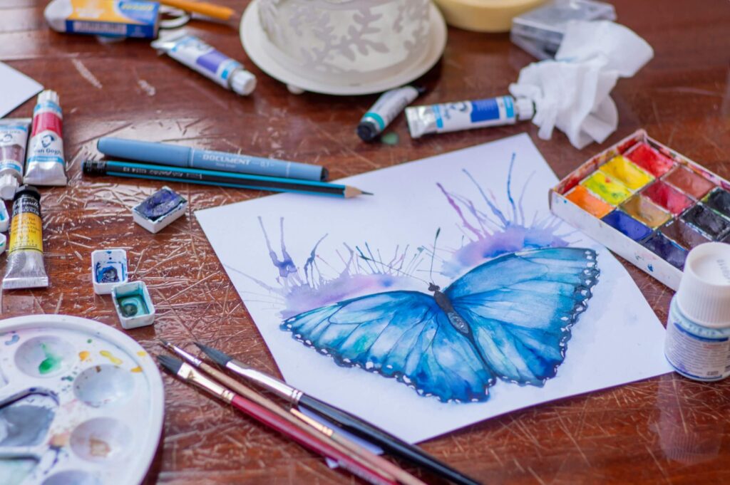 Someone creating a painted butterfly. Photo by Elena Mozhvilo on Unsplash