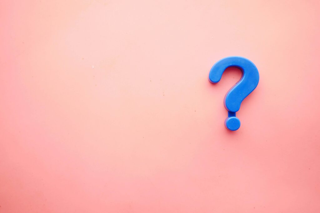 A blue question mark with a pink background. Photo by Towfiqu barbhuiya on Unsplash