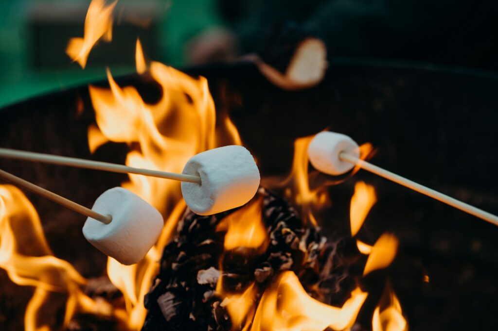 Three marshmallows roasting over a campfire. Photo by Leon Contreras on Unsplash