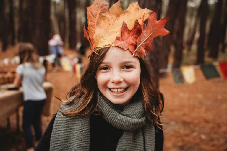 A young girl with a leaf crown on her head. Family camping in autumn. Photo by Jessie Maxwell on Unsplash