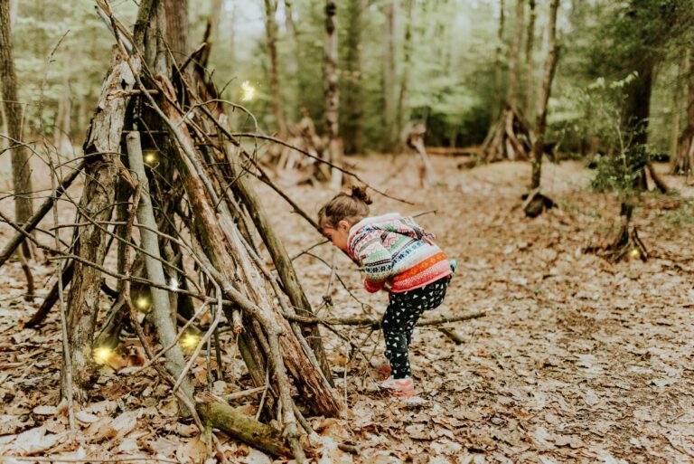 A little girl making a den. Autumn camping with toddlers. Photo by Sandra Seitamaa on Unsplash