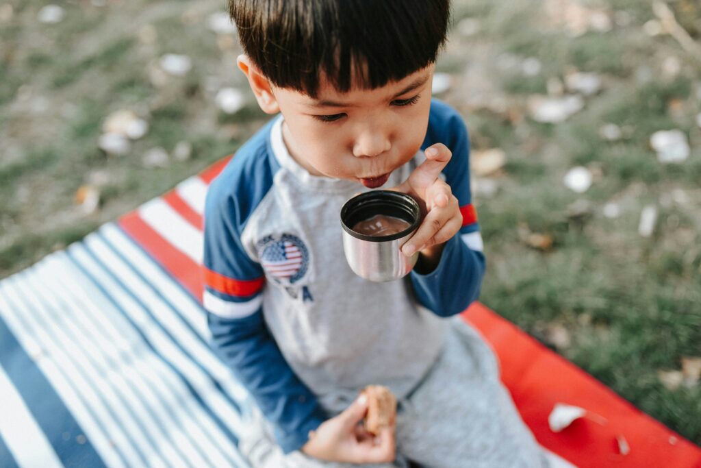 A toddler drinking a hot chocolate. Photo by Kris Len Lu on Unsplash