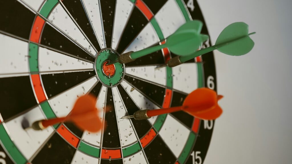 A dart board with darts in it. Photo by Afif Ramdhasuma on Unsplash