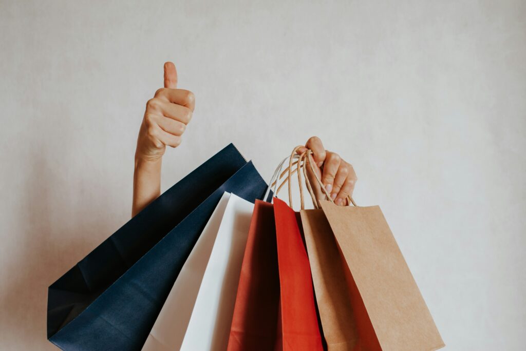 Someone holding shopping bags. Photo by Iuliia Pilipeichenko on Unsplash