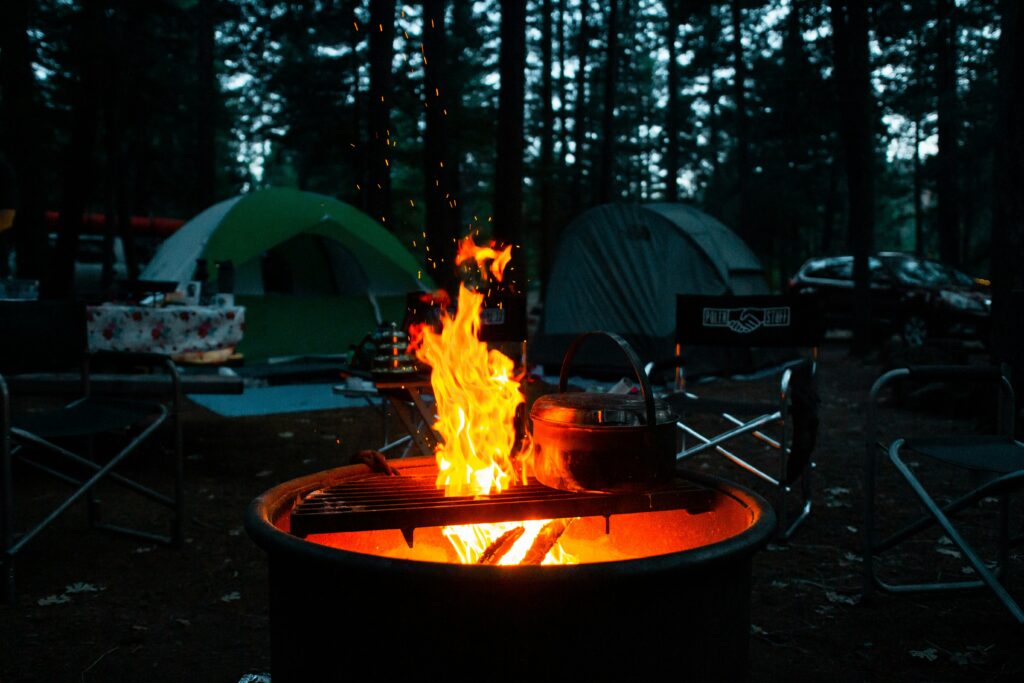Tents and tent chairs around a campfire. Photo by Ben Moreland on Unsplash