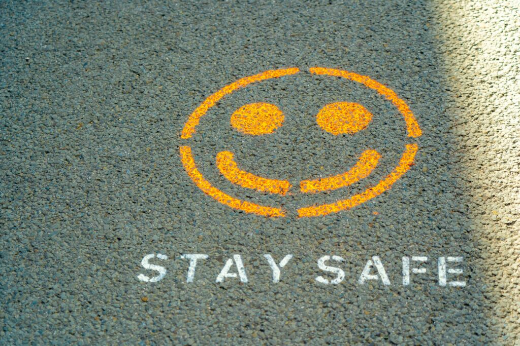 A "Stay Safe" sign with a smiley face. Photo by Nick Fewings on Unsplash