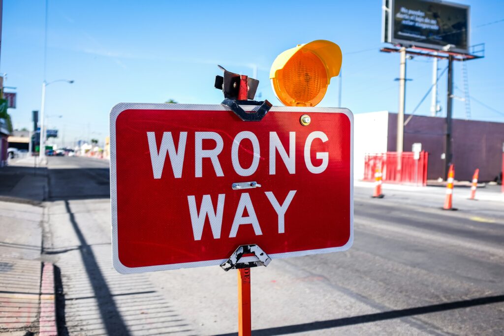 A wrong way sign in a road. Autumn camping mistakes. Photo by Kenny Eliason on Unsplash