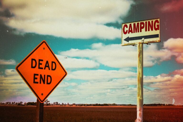 A camping sign and a dead end sign. Photo by Bailey Anselme on Unsplash