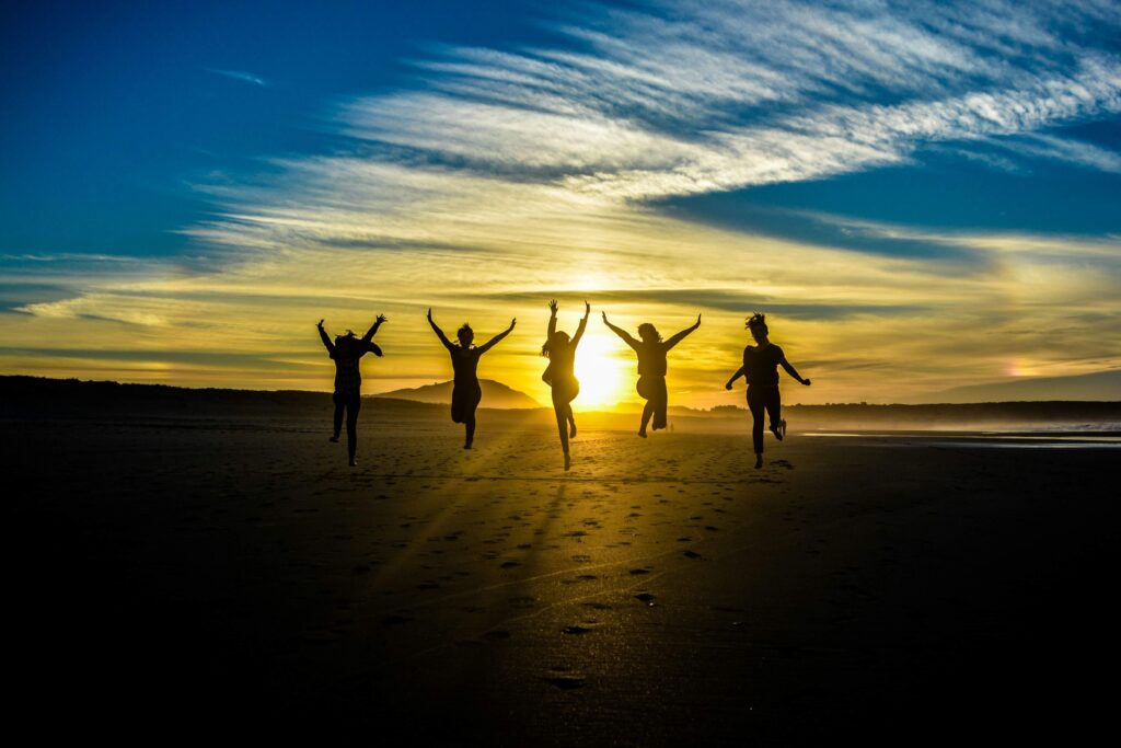 A group of five people jumping in the air. Marathon life lessons. Photo by Guille Álvarez on Unsplash