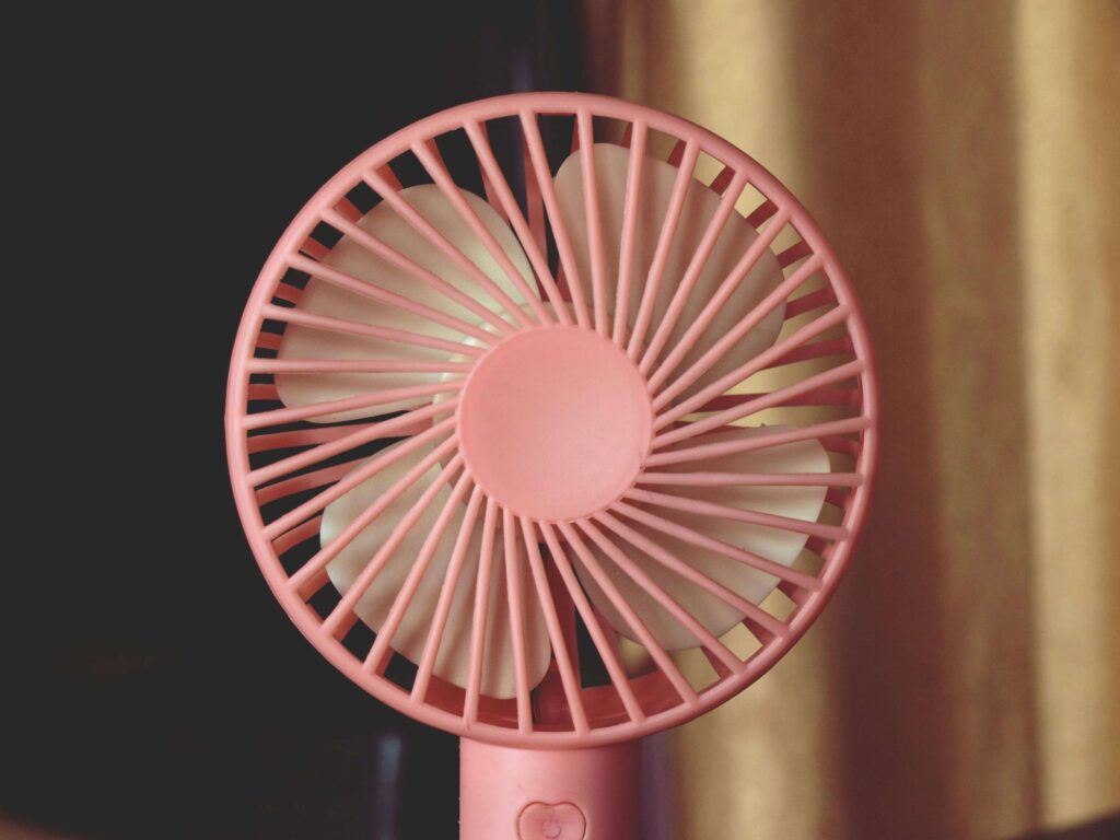 A pink portable fan. Photo by Chandan Chaurasia on Unsplash