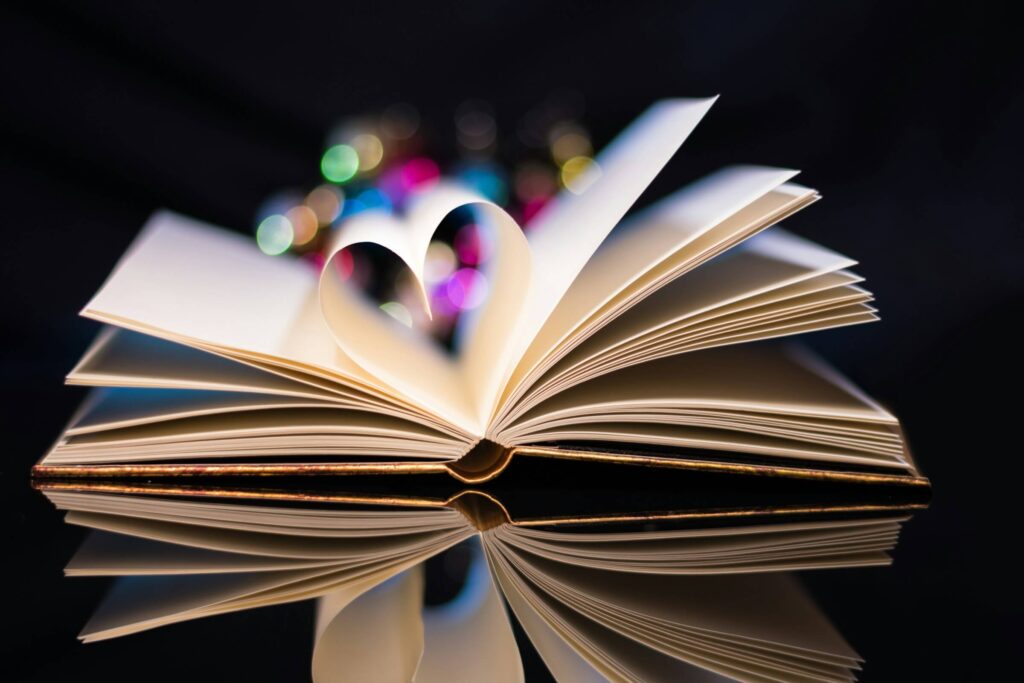 A book opened to the middle with the pages folded to create a heart shape. Hiking with kids. Photo by Theo Crazzolara on Unsplash
