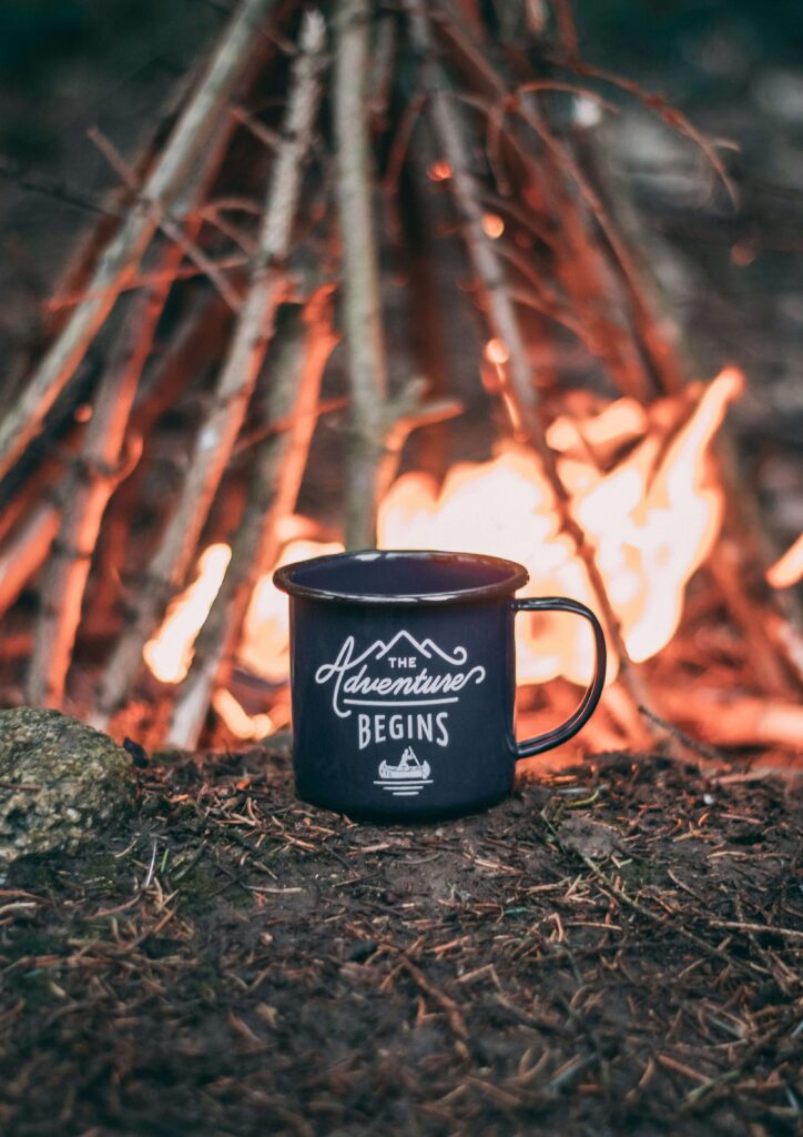 Positive camping mug that says "the adventure begins." Camping with anxious children. Photo by Ole Witt on Unsplash