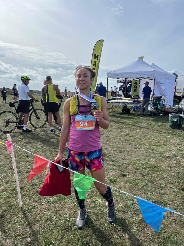 Rebecca at the finish line at the Run to the Sea Bournemouth 50k with her medal. Source: Rebecca Campbell Ltd